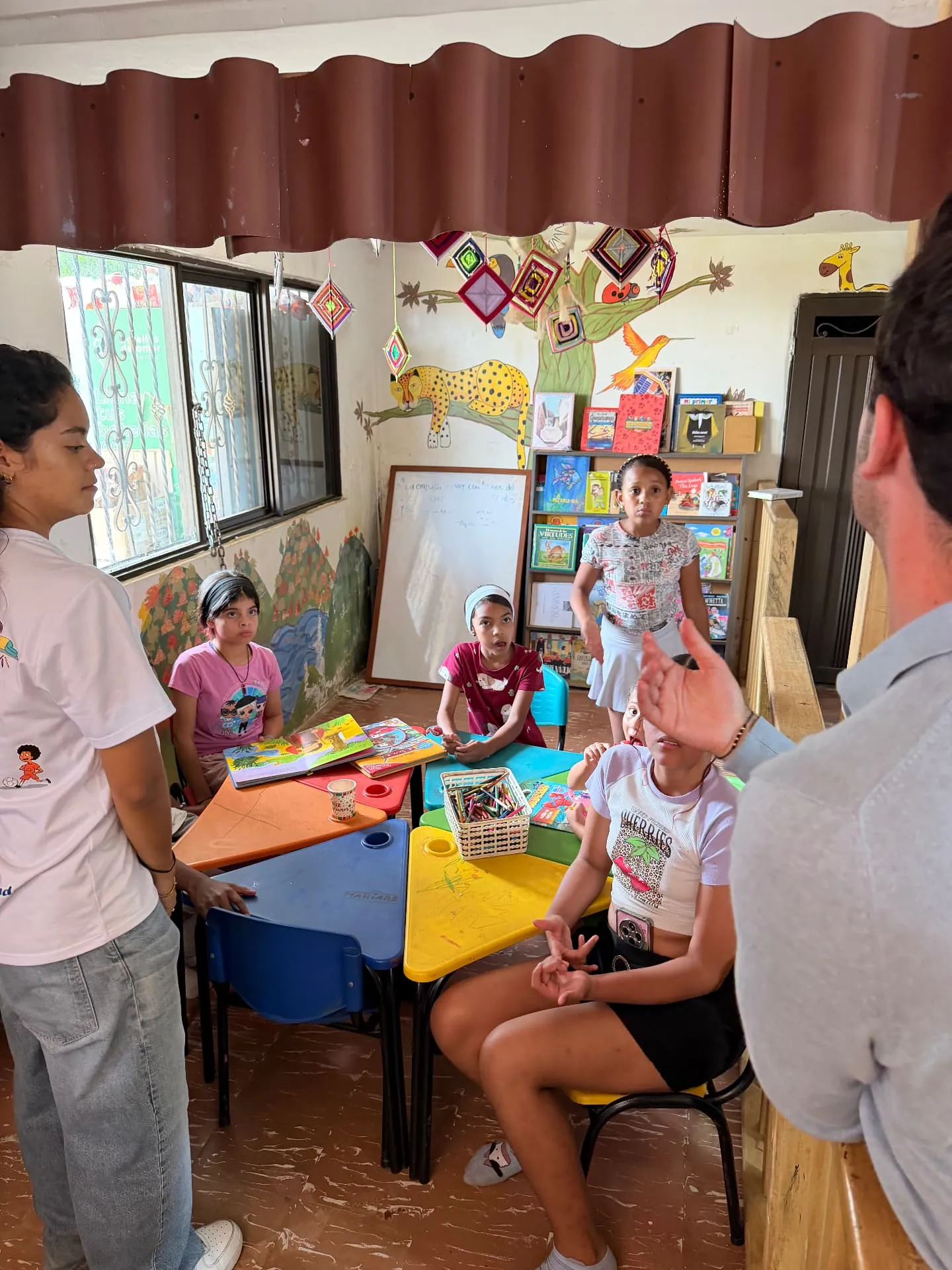 Children of Medellín Foundation: an after-school classroom session with children reading and drawing