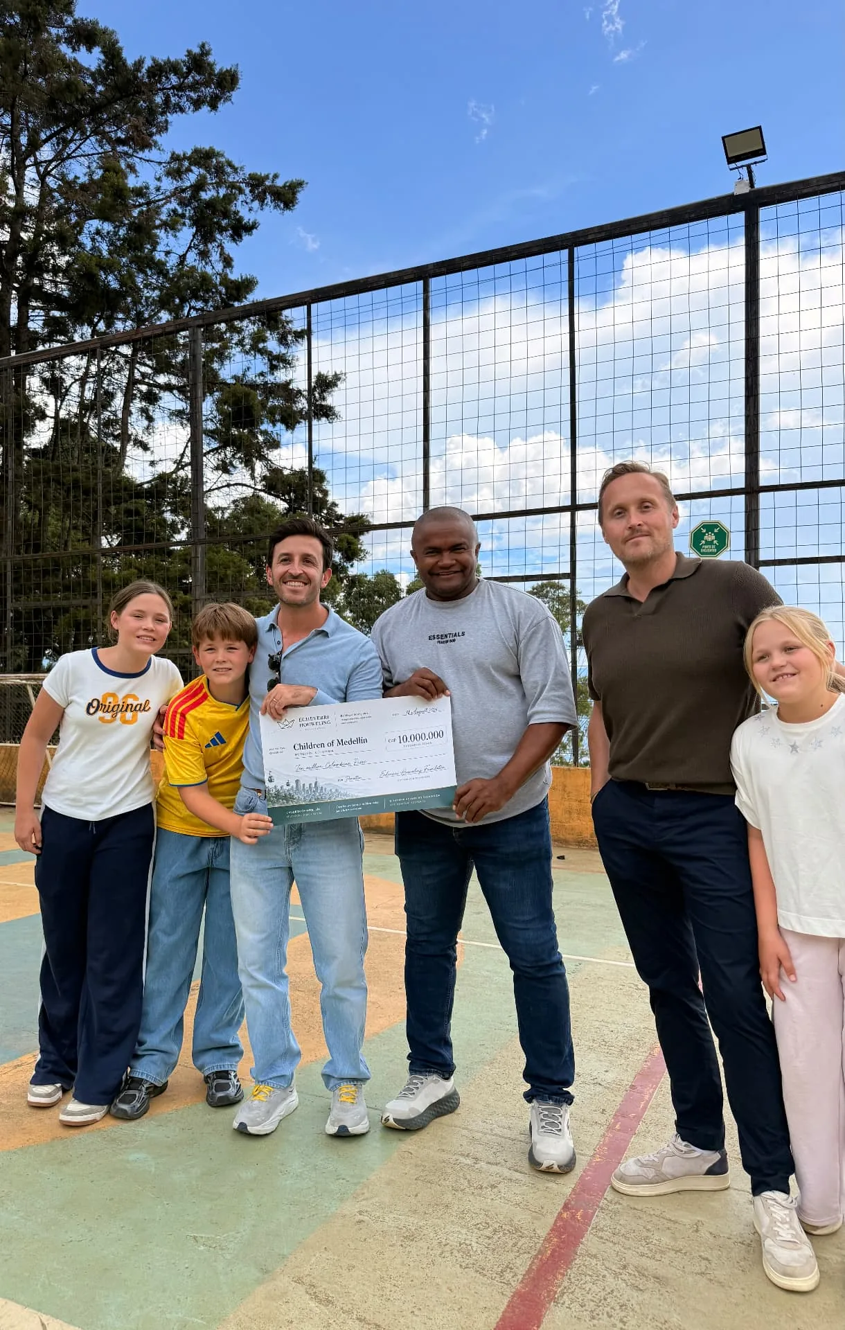 Our family handing over the COP 10,000,000 cheque to the Children of Medellín team on the neighbourhood sports court